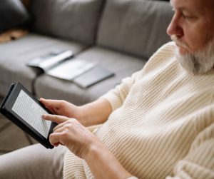 Man sitting on a sofa using an electronic tablet